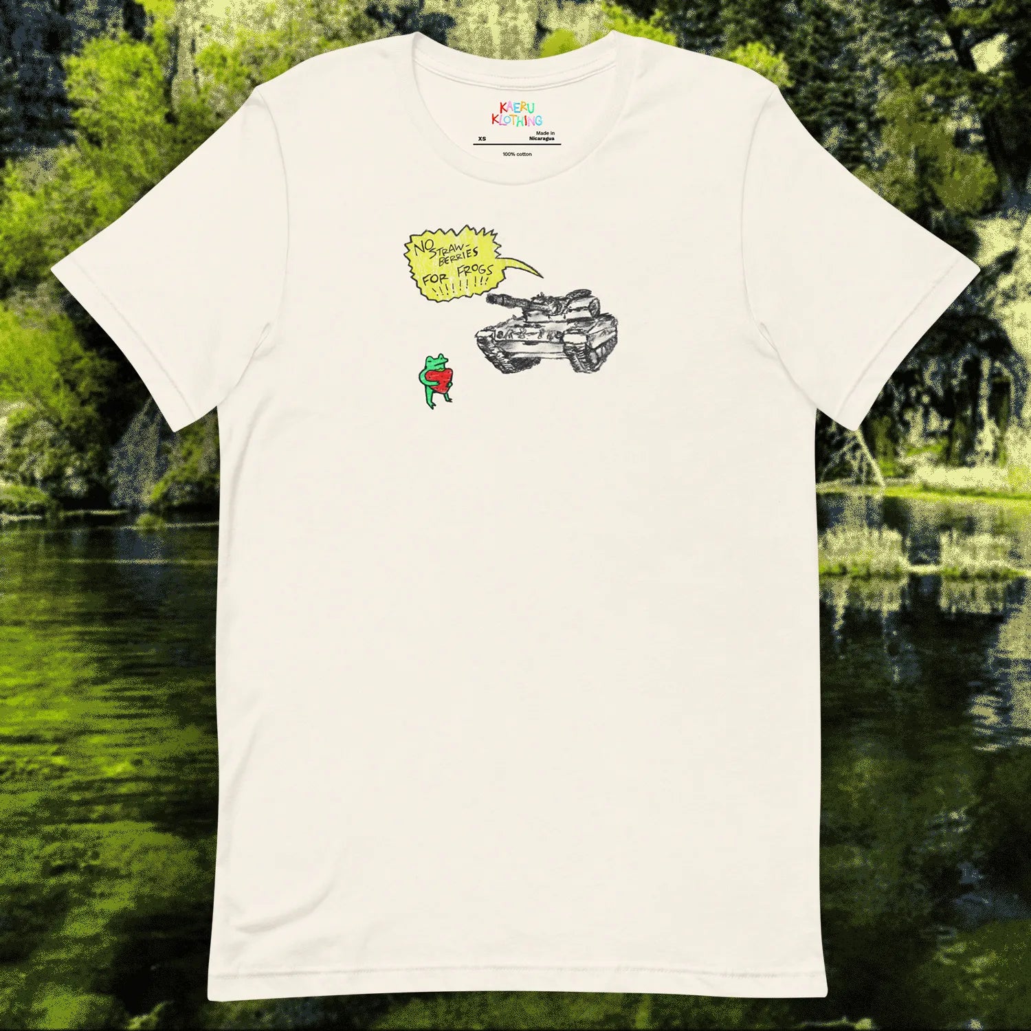 TANKRU TEE by Kaeru Klothing — white unisex cotton t-shirt laid flat, showing full hand-drawn graphic design of a frog holding a strawberry facing a tank with a yellow speech bubble reading “NO STRAWBERRIES FOR FROGS.”